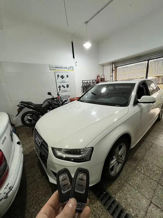 Audi A4 blanco dentro del taller con dos llaves de proximidad