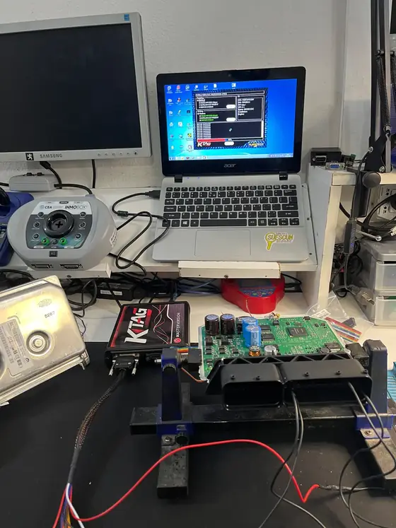 Banco de trabajo con ECU abierta, programador KTAG y equipo INMOBOX