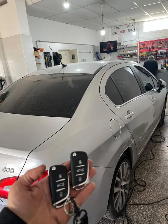 Peugeot 408 gris en el taller con dos llaves navaja